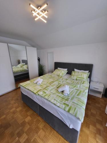 a bedroom with a large bed with two towels on it at Apartmaji Peric in Ljubljana