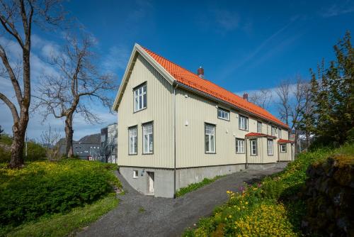 a house with an orange roof on a street at Lofoten Summer Apartments in Kabelvåg