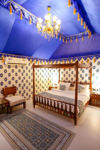 a bedroom with a bed and a blue ceiling at Gulbag Heritage in Jaipur