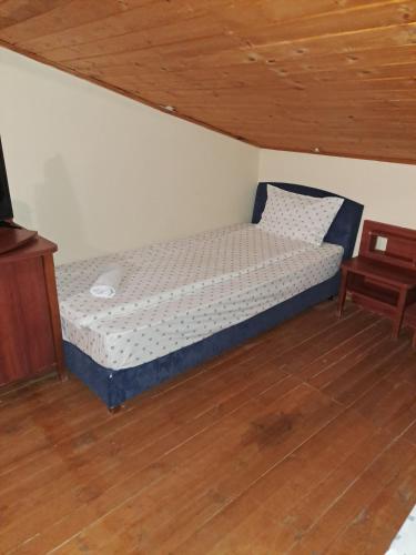 a small bed in a room with a wooden ceiling at Стария Чинар in Melnik