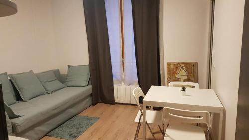 a living room with a couch and a table at Studio cosy, quartier canal Saint-Martin in Paris