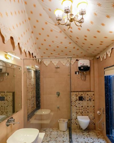 a bathroom with a shower and a toilet and a sink at Gulbag Heritage in Jaipur