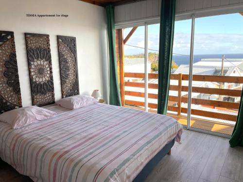 a bedroom with a bed and a large window at Alambic de Grand Anse in Petite Île