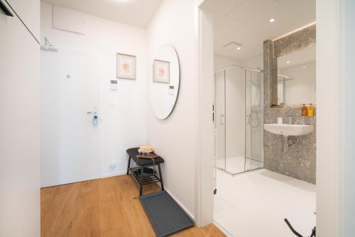 a white bathroom with a sink and a mirror at apartino - FREE parking, 10 minutes walk to city centre, nespresso, netflix in Brno