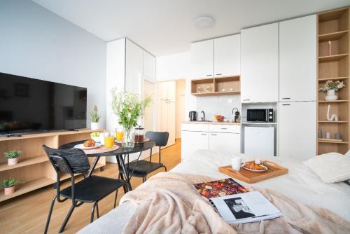 a room with a bed and a table with chairs at apartino - FREE parking, 10 minutes walk to city centre, nespresso, netflix in Brno