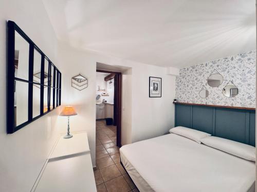 a bedroom with a bed and a lamp on a table at La Cachette d'Antibes in Antibes