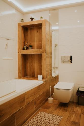 a bathroom with a toilet and a tub and a sink at Willa Murena in Mielno