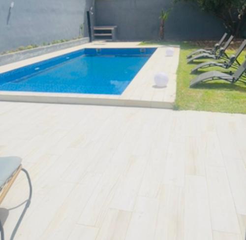 a swimming pool in a yard with chairs around it at Villa Naouma in Marrakech