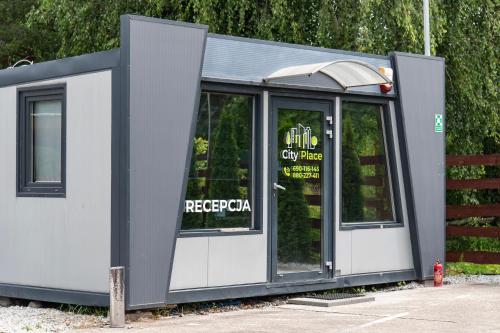 a building with glass doors on the side of it at City Place Noclegi in Wrocław
