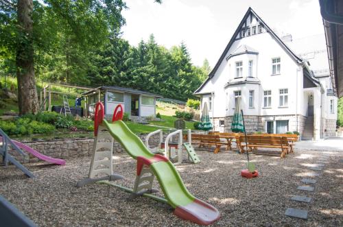 a playground with a bunch of slides in front of a house at WILLA DobraNocka in Szklarska Poręba