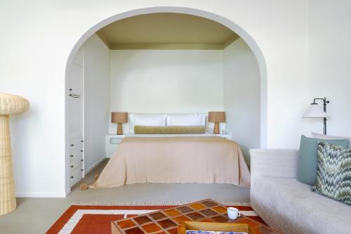 a bedroom with a bed and a couch at Vilalara Grand Hotel Algarve in Armação de Pêra