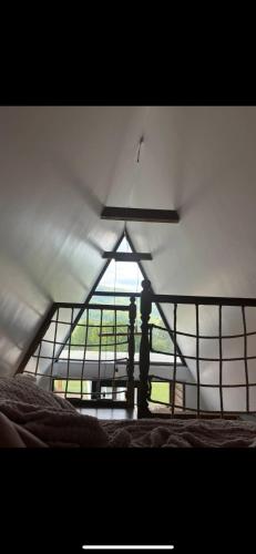 a room with a large window and a bed at VictoriA-Frame in Nucşoara