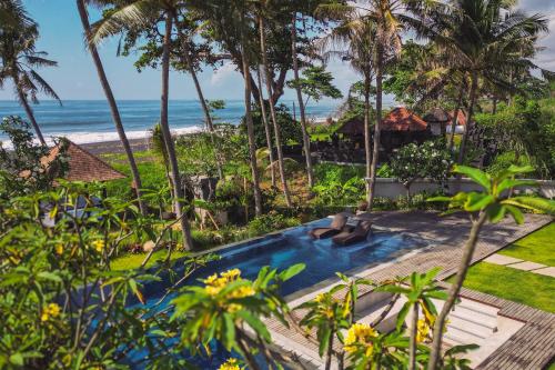 an aerial view of a resort with a swimming pool and the beach at K Ko Surf Village at Keramas in Lebih