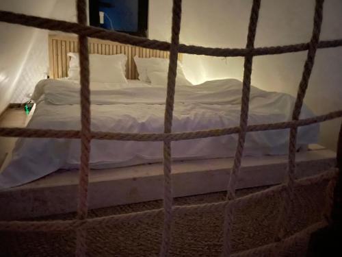 a bed with white sheets and pillows in a room at VictoriA-Frame in Nucşoara