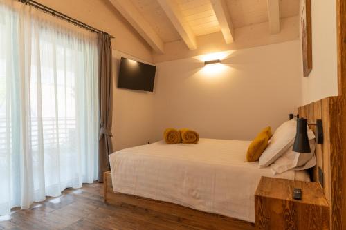 a bedroom with a bed with two towels on it at Fai le Coccole in Fai della Paganella