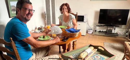 a man and a woman sitting at a table at Penn Ar Bed & Breakfast in Plozévet