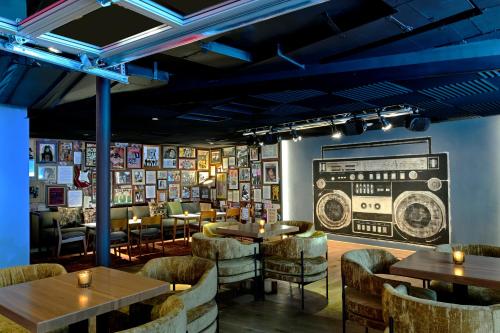 a restaurant with tables and chairs and a radio on the wall at Hotel Ziggy On Sunset in Los Angeles