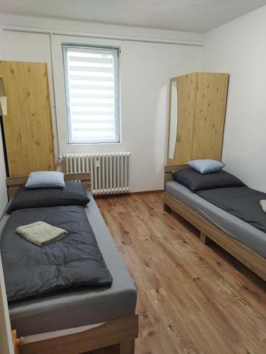 a bedroom with two beds and a window at Márti Apartman in Sátoraljaújhely