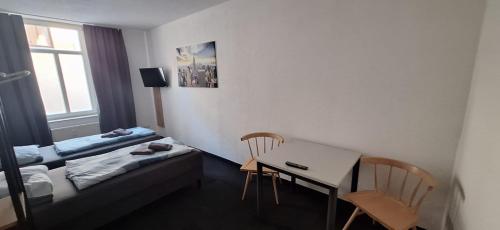 a room with a desk and a bed and a table and chairs at Kunstgasse 11, Wohnung 2, EG in Altenburg