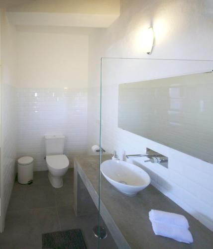 a bathroom with a sink and a toilet and a mirror at Moinhos das Marés in Fuzeta
