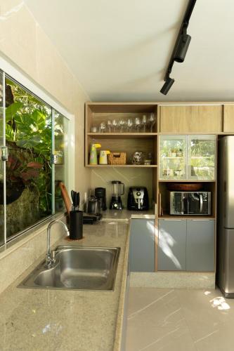 a kitchen with a sink and a stainless steel refrigerator at Casa no Lago in Ananindeua
