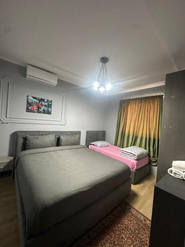 a bedroom with two beds and a tv on the wall at Holiday Apartments in Tirana