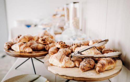 two plates of pastries and croissants on a table at Hotel Eldorado in Apiro