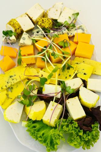 a plate of cheese and vegetables on a white plate at Hotelik & Restauracja Amber in Raszyn