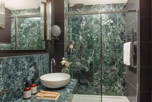 a bathroom with a sink and a glass shower at NH Collection Milano President in Milan