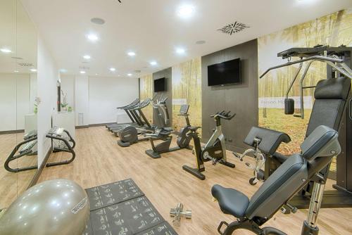 a gym with several treadmills and exercise bikes at NH Collection Milano President in Milan