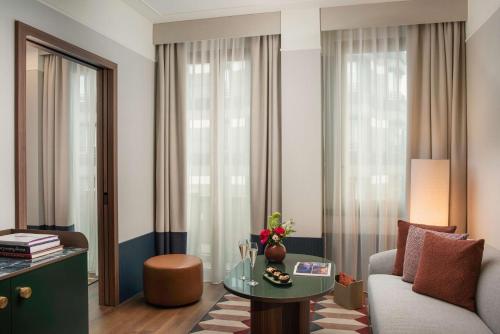a living room with a couch and a table at NH Collection Milano President in Milan