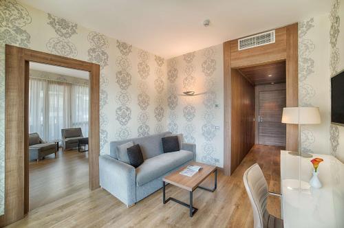 a living room with a blue couch and a table at NH Collection Milano President in Milan