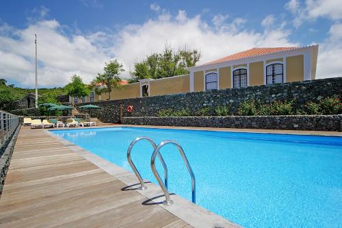 a swimming pool in front of a house at Quinta das Merces in Angra do Heroísmo