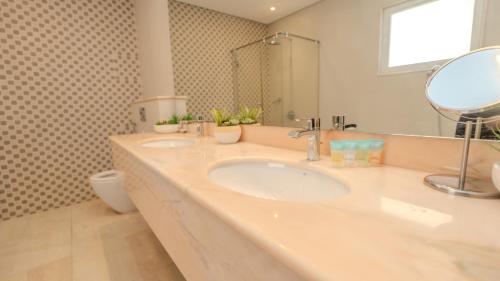 ein Badezimmer mit zwei Waschbecken und einem Spiegel in der Unterkunft Beach Front Bermuda Villa Mina AlArab Ras Al Khaimah in Ras al Khaimah