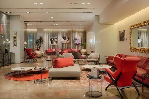 a living room with couches and chairs and tables at NH Collection Milano President in Milan