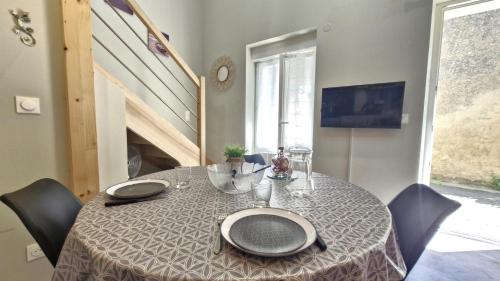 une salle à manger avec une table et des chaises et un escalier dans l'établissement Saint Georges de Didonne - EMPLACEMENT PRIVILIGIE pour un SEJOUR à DEUX ou en SOLO, à Saint-Georges-de-Didonne