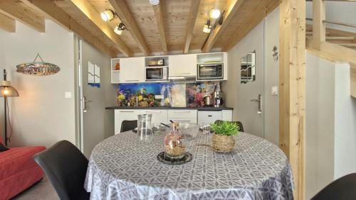 une salle à manger avec une table et une cuisine dans l'établissement Saint Georges de Didonne - EMPLACEMENT PRIVILIGIE pour un SEJOUR à DEUX ou en SOLO, à Saint-Georges-de-Didonne