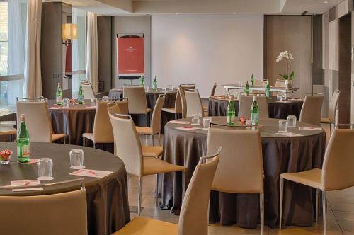 a conference room with tables and chairs with bottles on them at NH Collection Milano President in Milan