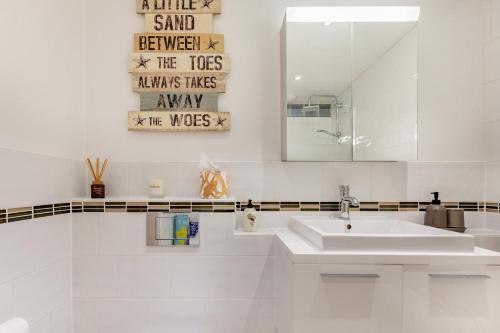 Un baño blanco con lavabo y espejo. en 1 Bed in Braunton oc-g32527, en Braunton