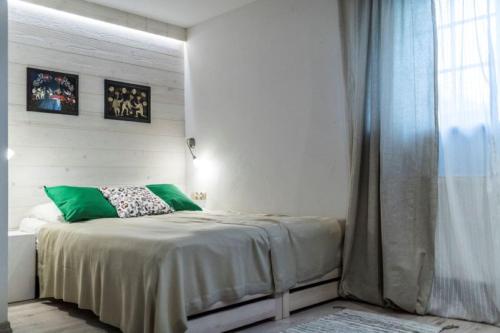 a bedroom with a bed with green pillows and a window at Willa Leluja in Zakopane