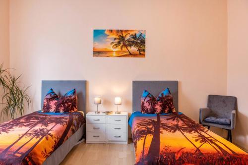 a bedroom with two beds and a chair at Ferienwohnung Burgblick in Plaue