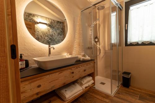 a bathroom with a sink and a shower at Fai le Coccole in Fai della Paganella