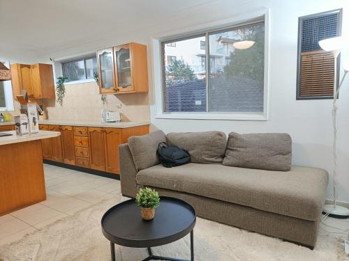 ein Wohnzimmer mit Sofa und Tisch in der Unterkunft Queen Room in Carlingford near Shops and Station - NC4 in Stanwell Park