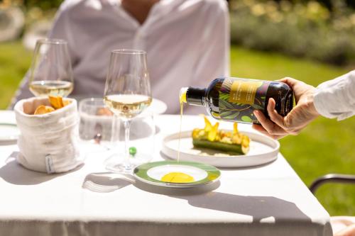 a person pouring white wine into a plate of food at Roccafiore Wine Resort & Spa in Todi