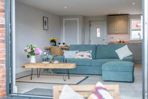 a living room with a blue couch and a table at 1 Bed in Marishes oc-l32536 in Kirby Misperton