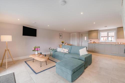 a living room with a blue couch and a table at 1 Bed in Marishes oc-l32536 in Kirby Misperton