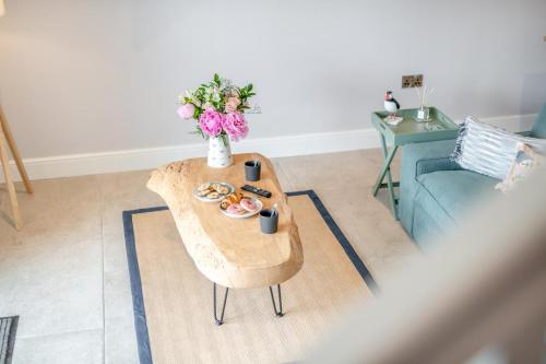 a table in a living room with a vase of flowers at 1 Bed in Marishes oc-l32536 in Kirby Misperton