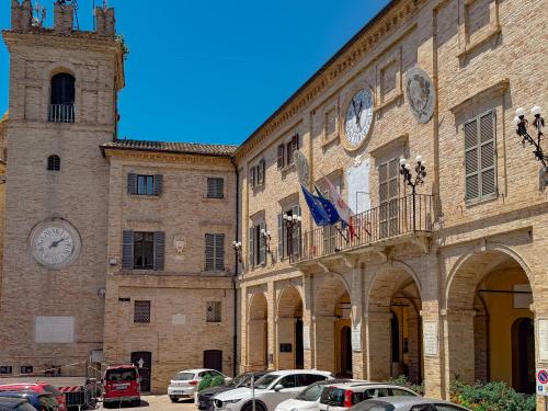 a large brick building with cars parked in front of it at Relax & Views in Le Marche by Host Hero in Morrovalle