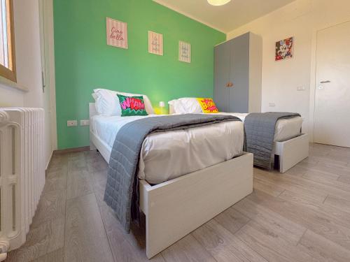 two beds in a room with green walls at Relax & Views in Le Marche by Host Hero in Morrovalle