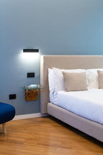 a bedroom with a bed and a light on the wall at Deluxe Spaccanapoli in Naples